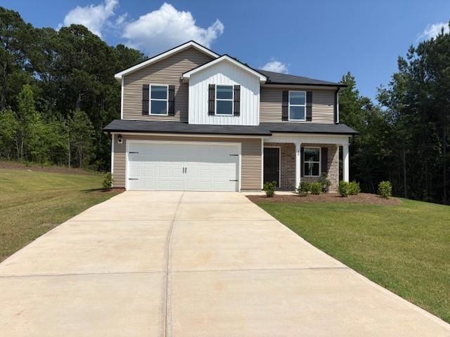 View of front facade featuring concrete driveway, an attached garage, a front yard, and board and batten siding