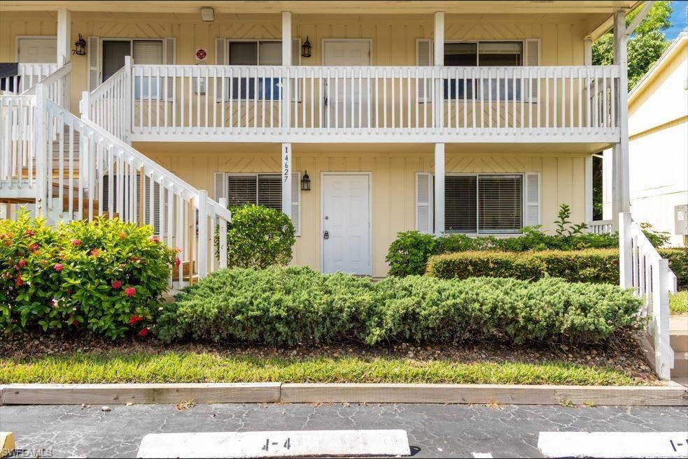 View of front facade featuring stairs and a balcony