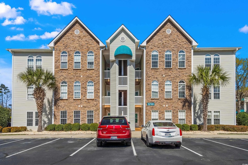 View of building exterior with uncovered parking