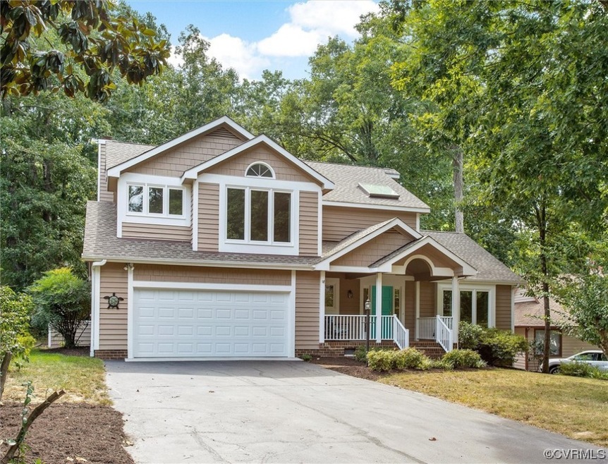 View of front of property featuring garage, a porch, and a front lawn