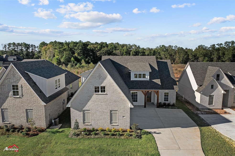 View of front of house with central AC unit and a front yard