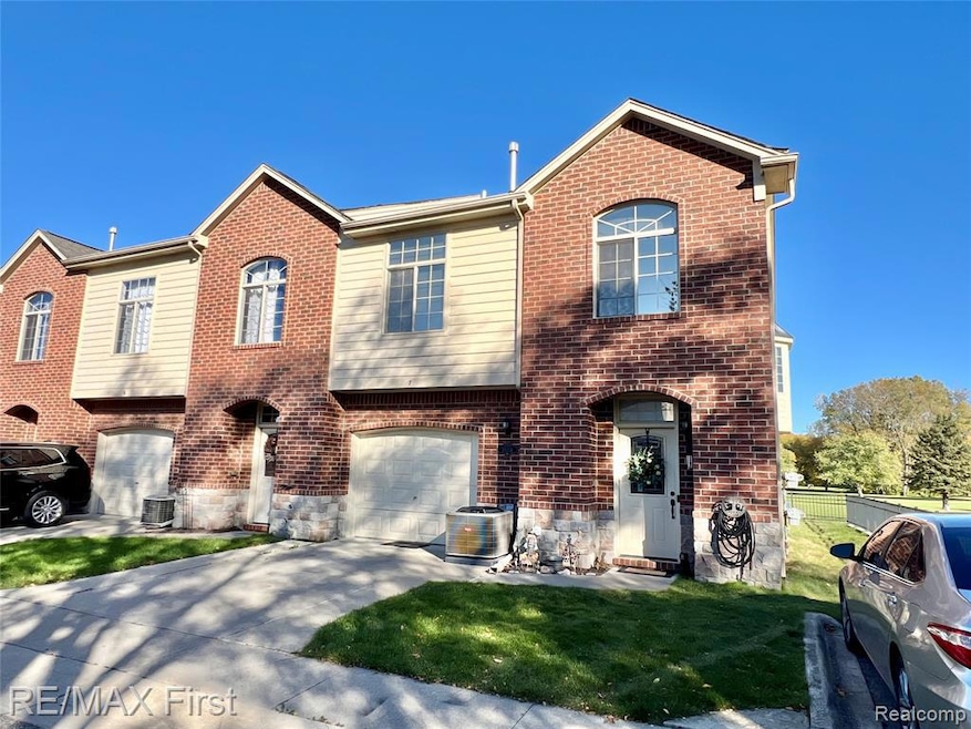 View of front of home featuring a front lawn, brick siding, and concrete driveway