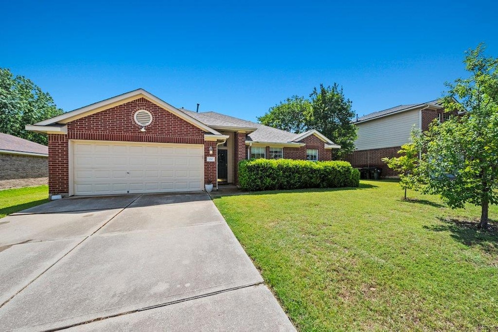 Ranch-style house with driveway, a garage, brick 