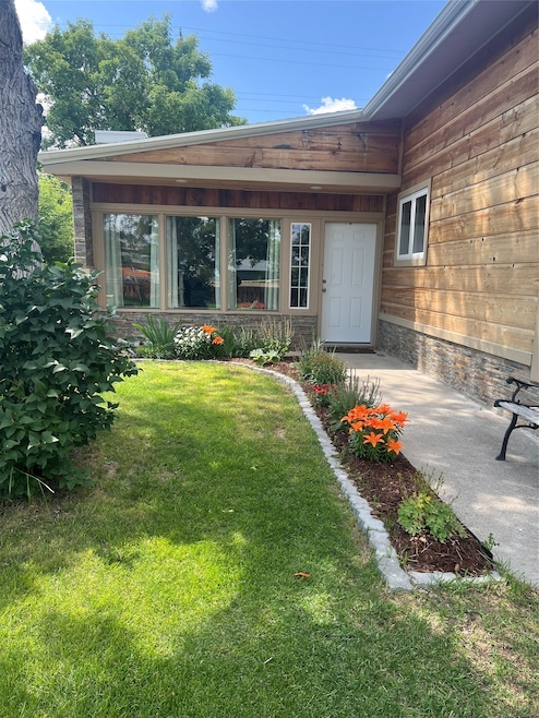 View of exterior entry with a lawn