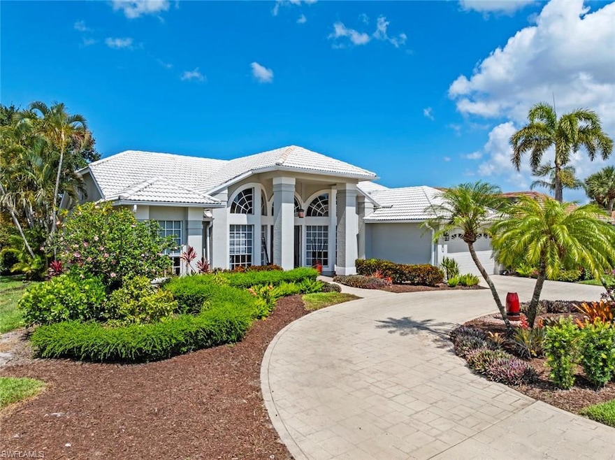 View of front of property featuring curved driveway, a tile roof, stucco siding, and an attached garage