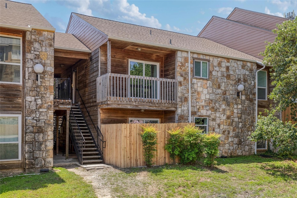 Rear view of property featuring stone siding, sta