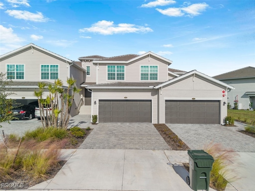 View of front facade featuring decorative driveway and a garage