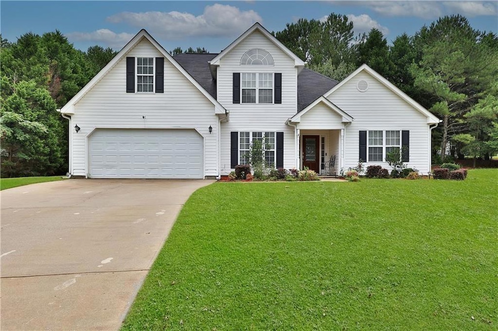 Traditional-style house with driveway, a front yard, and an attached garage