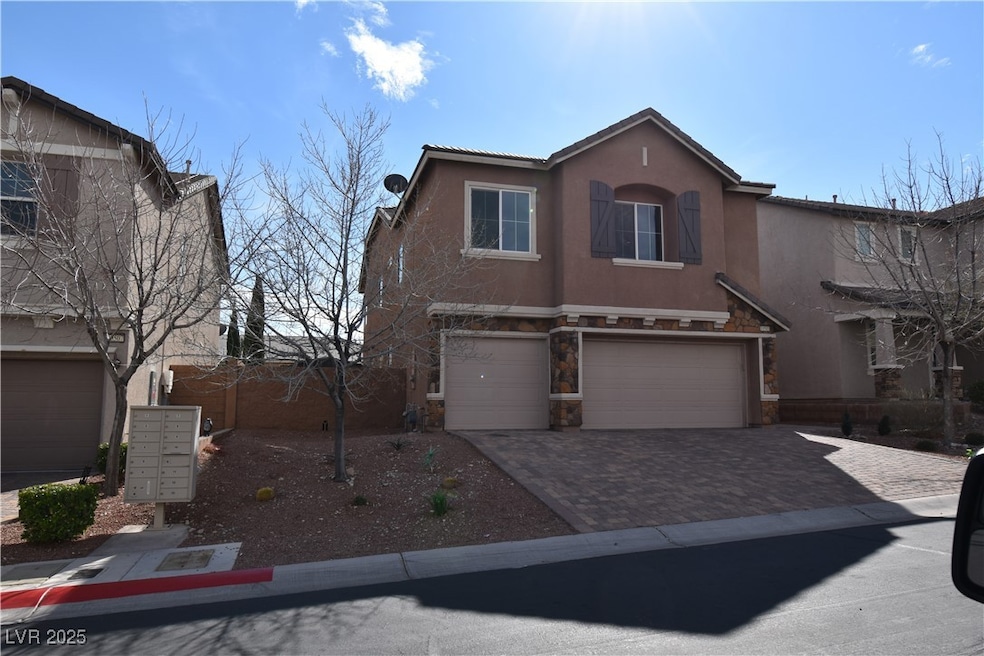 View of front facade featuring stucco siding, an attached garage, decorative driveway, and stone siding