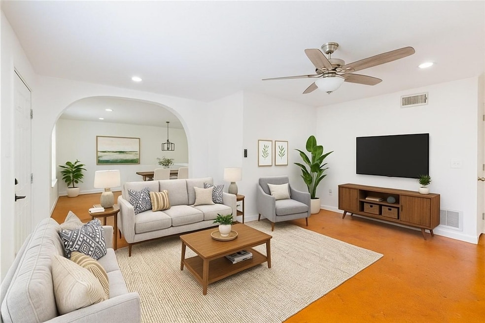 Living room with arched walkways, a ceiling fan, 