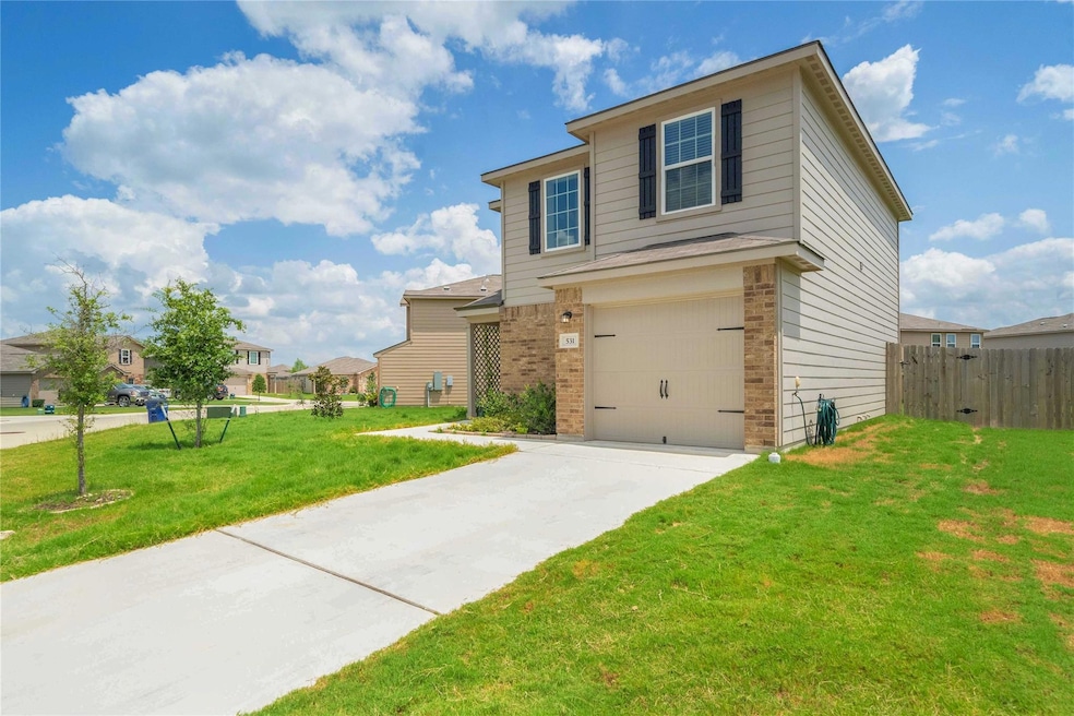 View of front of property featuring a garage, bri