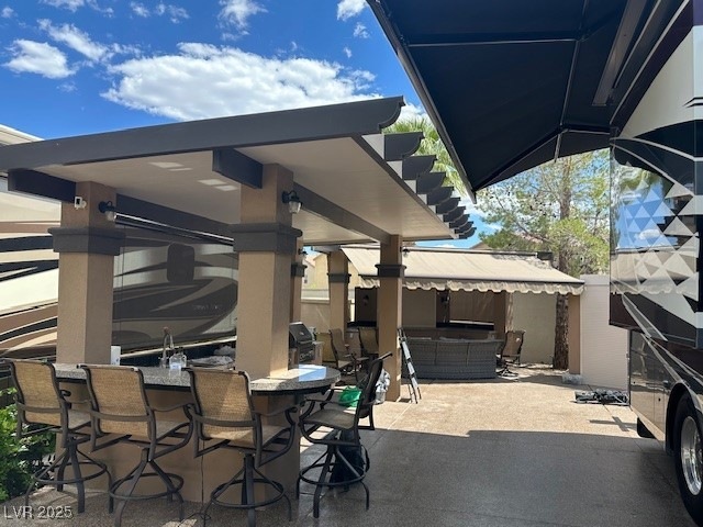 View of patio with an outdoor bar and grilling are