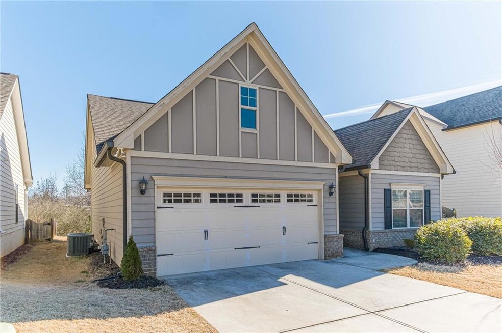 View of front of home with a garage and central AC