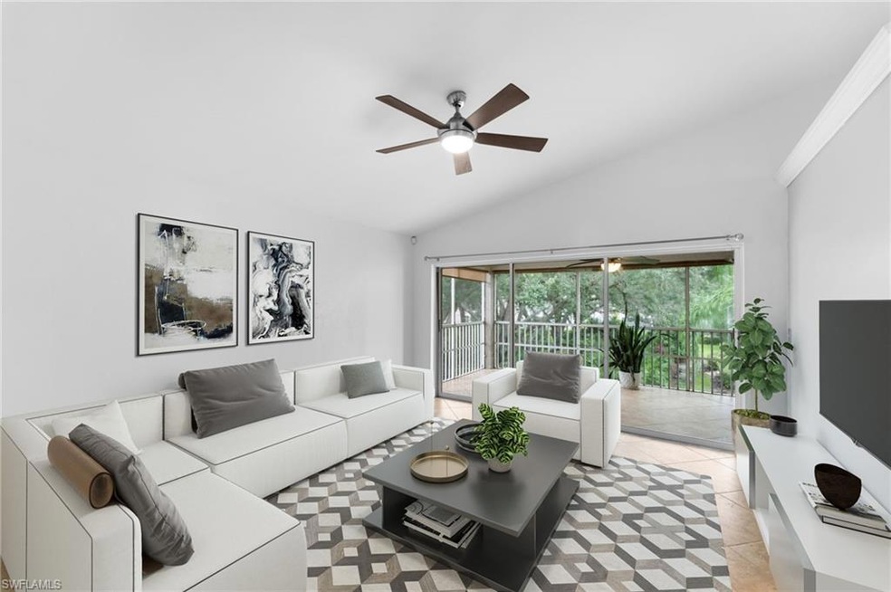 Tiled living room with ceiling fan and vaulted cei