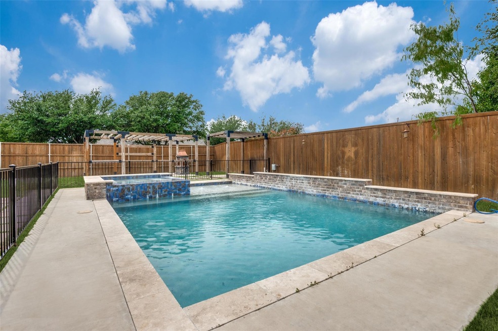 View of pool with an in ground hot tub and pool water feature