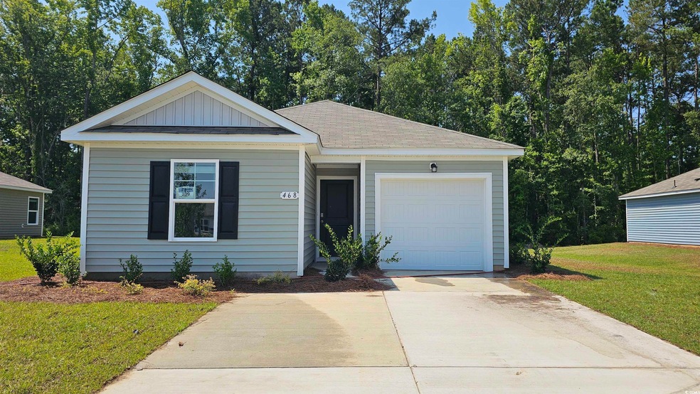 View of front of home with a garage and a front ya