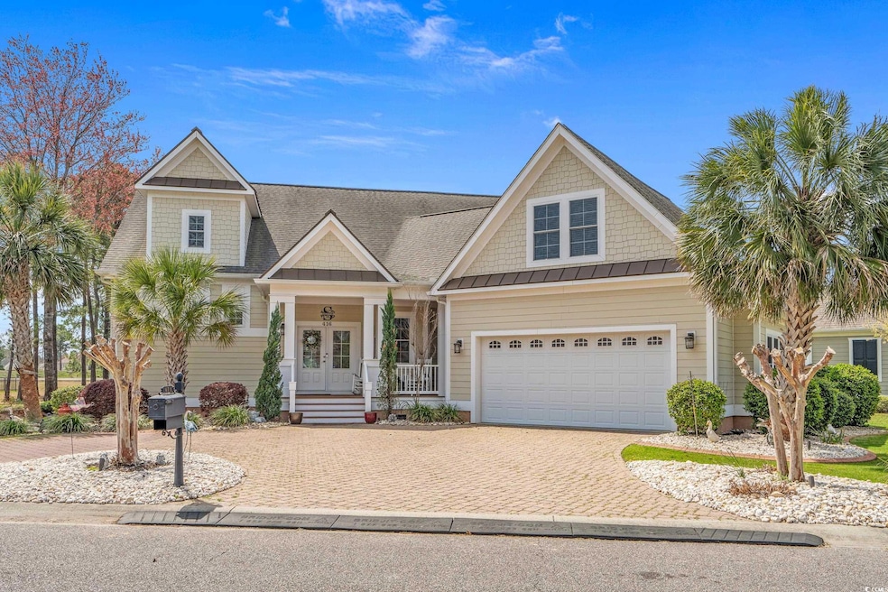 View of front of house featuring decorative driveway, a garage, a standing seam roof, covered porch, and french doors