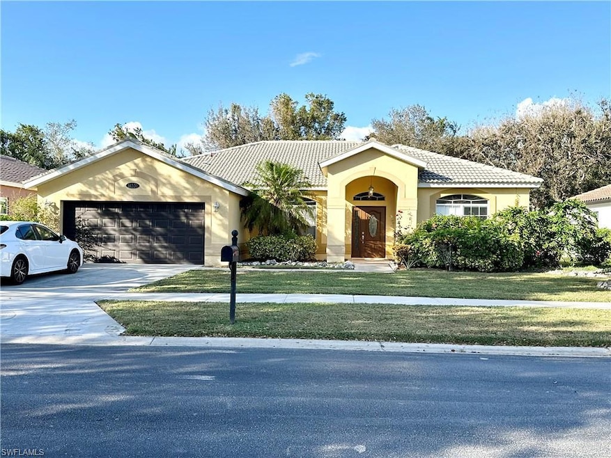 View of front facade featuring a garage and a front yard