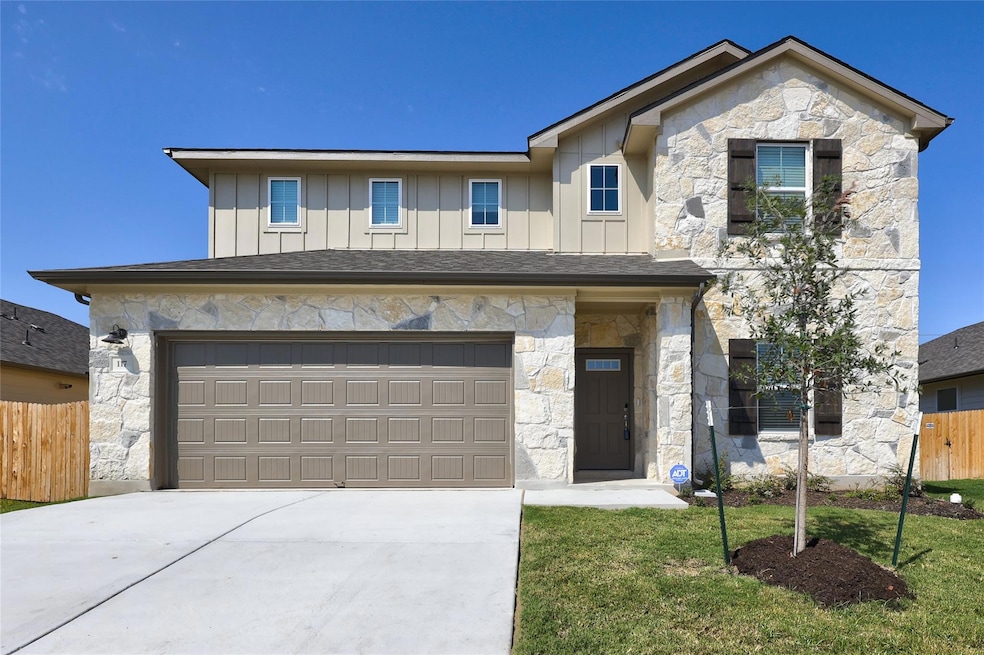 View of front of house with stone siding, board a