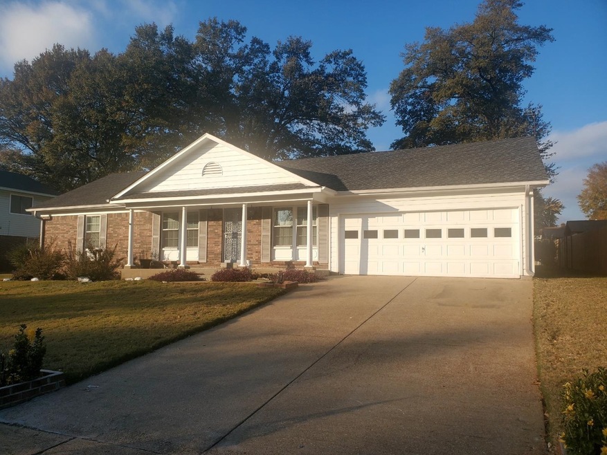 View of front facade with covered porch, a garage,