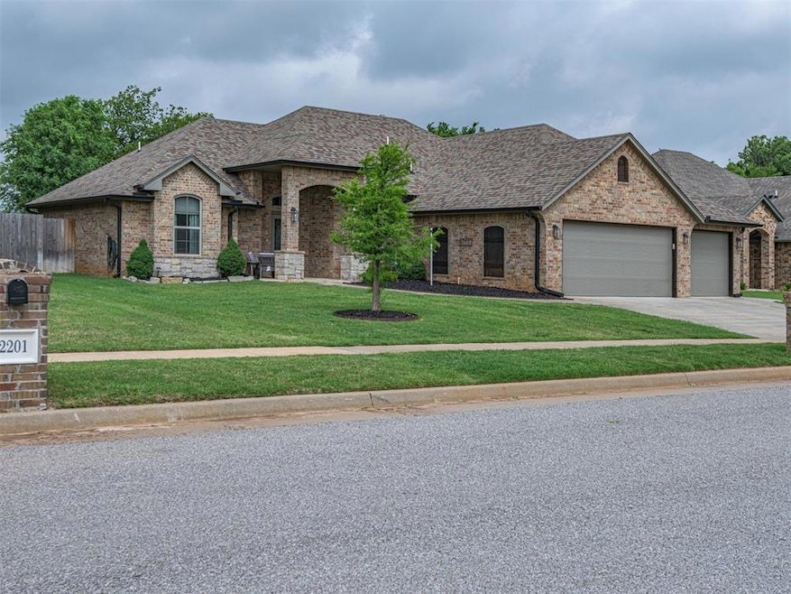 French country home with an attached garage, brick siding, driveway, and a shingled roof