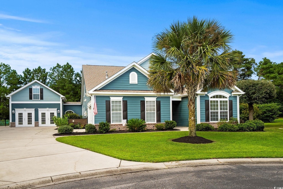 View of front of property featuring french doors, a front yard, concrete driveway, and brick siding