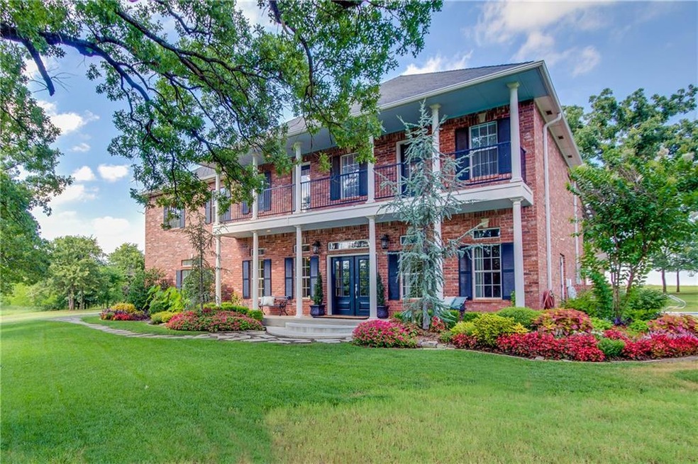 Beautiful home is nestled in trees and flower beds