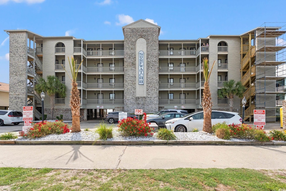 View of apartment building / complex featuring uncovered parking