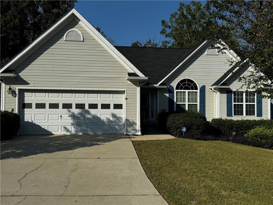 Ranch-style house with a garage and a front lawn