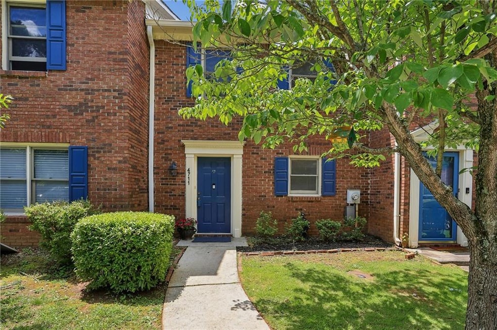 Entrance to property featuring brick siding and a lawn