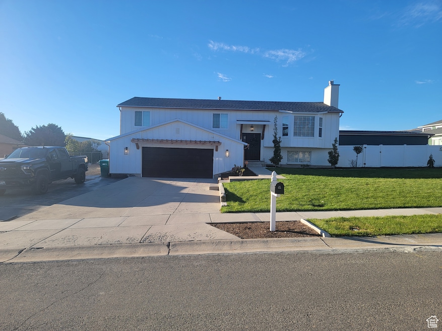 Raised ranch with a chimney and driveway