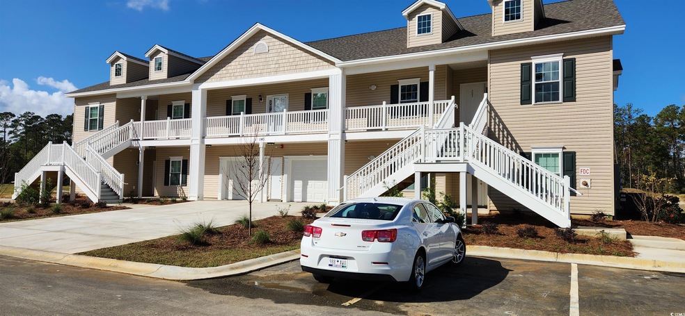 View of front of property with a garage and a porc