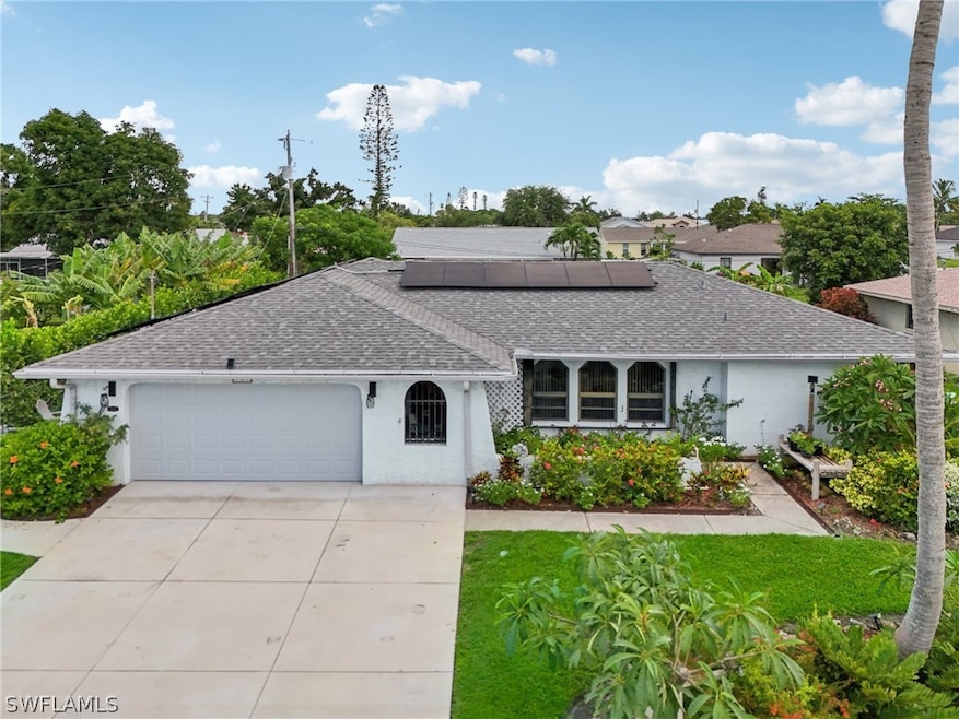 Ranch-style house featuring a garage and solar panels