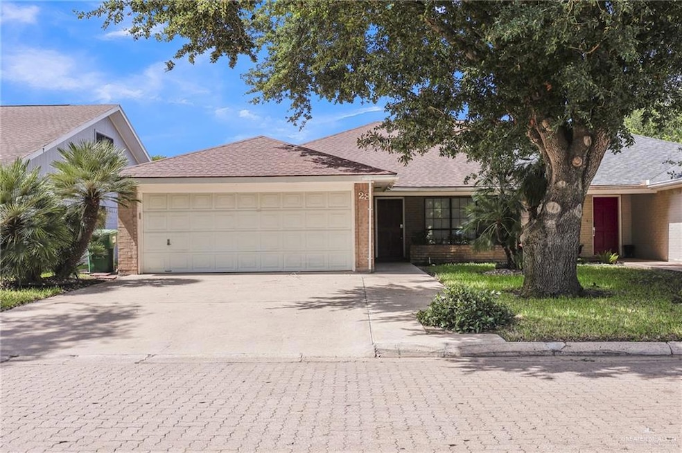 Ranch-style house with concrete driveway, a garage, brick siding, and roof with shingles