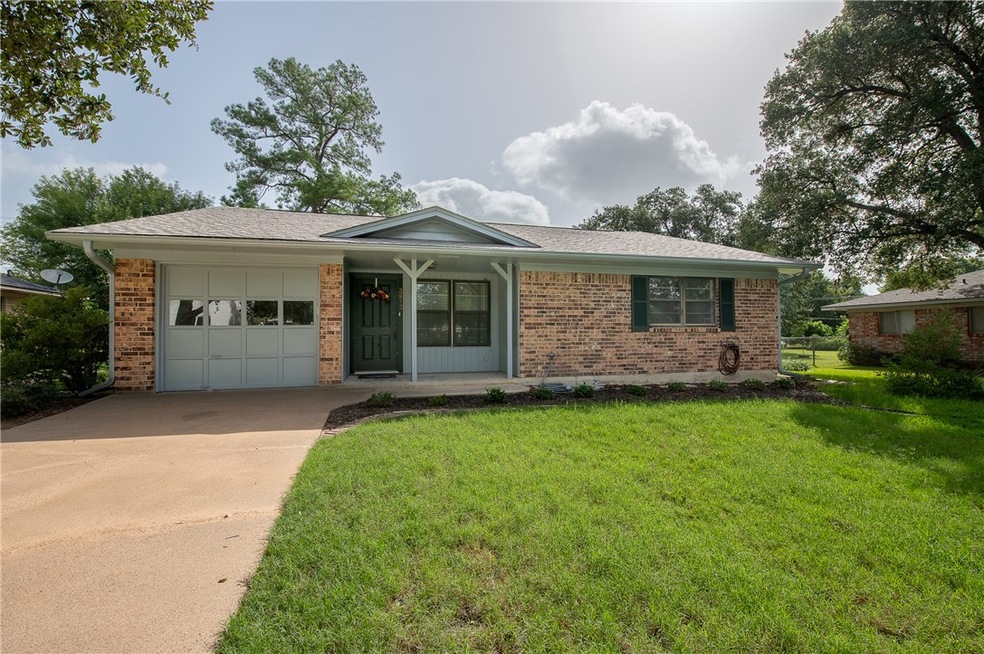 Single story home featuring a front yard and a gar