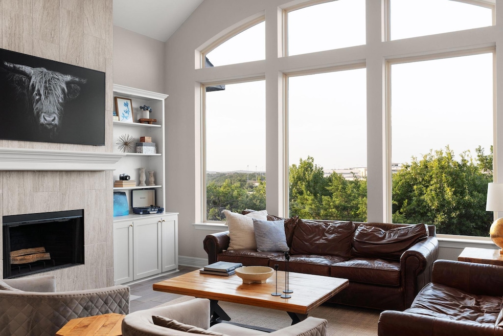 Living area featuring a tiled fireplace, light wo