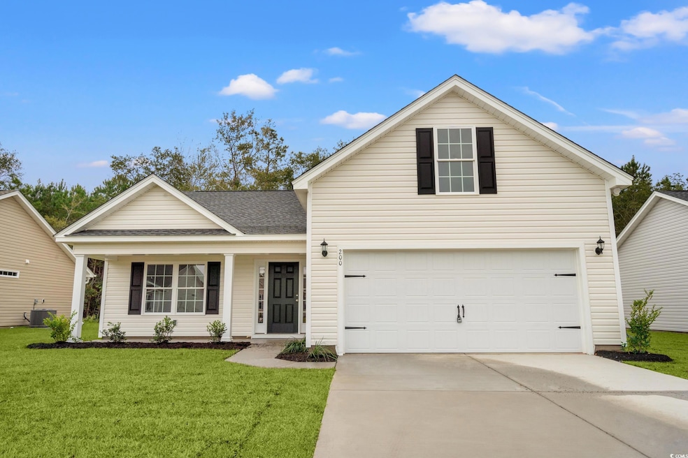 Traditional home featuring a porch, a front yard, a shingled roof, and driveway