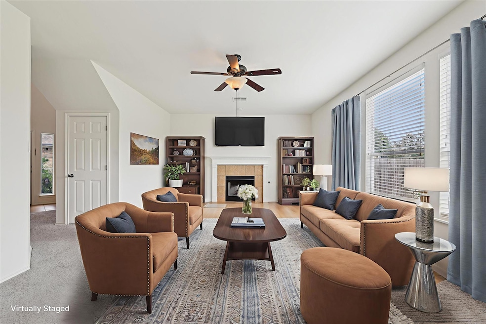 Living area featuring a ceiling fan and a firepla