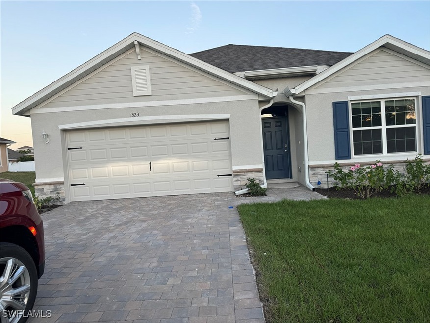Ranch-style house featuring stone siding, driveway