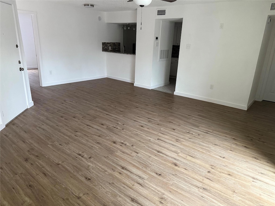 Unfurnished living room featuring dark wood-type f