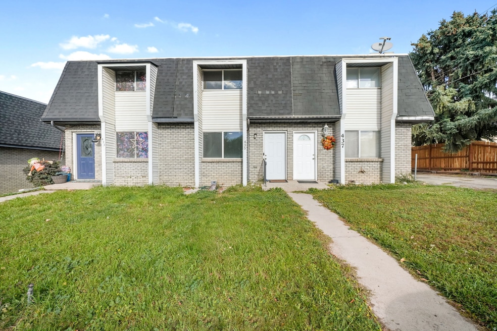 View of front of home featuring brick siding, roof with shingles, and mansard roof