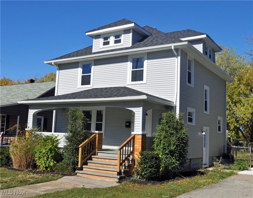 American foursquare style home featuring covered porch and roof with shingles