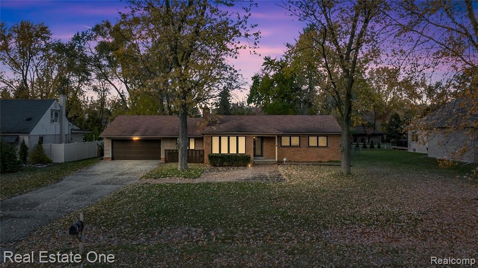 View of front of home with driveway, brick siding, and a garage