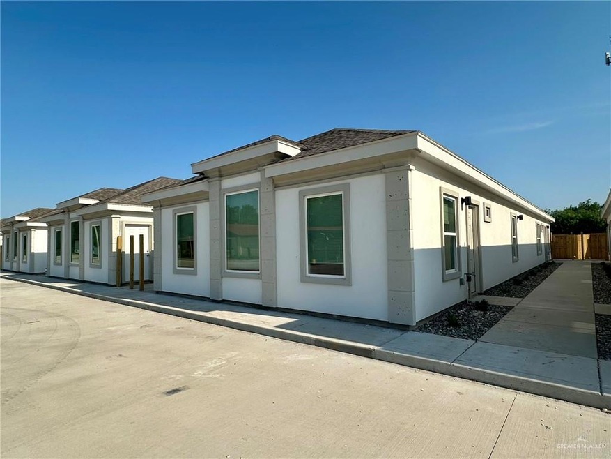 View of property exterior featuring fence, roof with shingles, and stucco siding