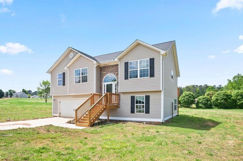 Bi-level home with an attached garage, a front law