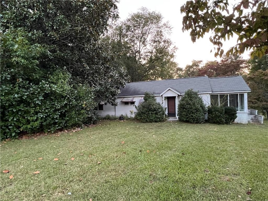 Ranch-style home featuring a front lawn