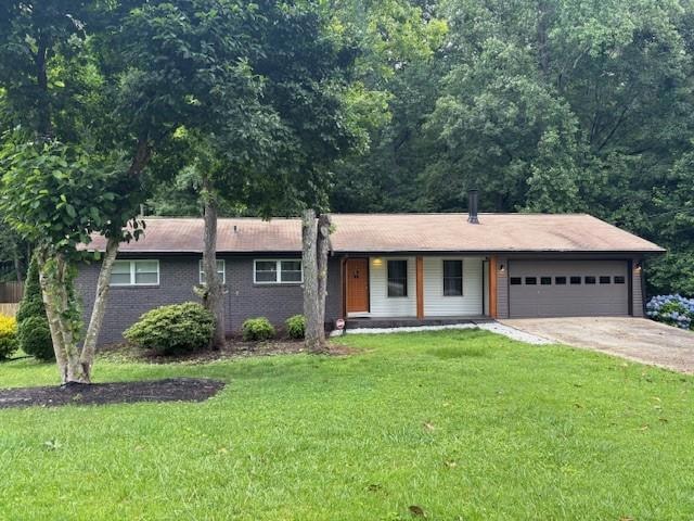 Single story home with an attached garage, driveway, a front lawn, and covered porch