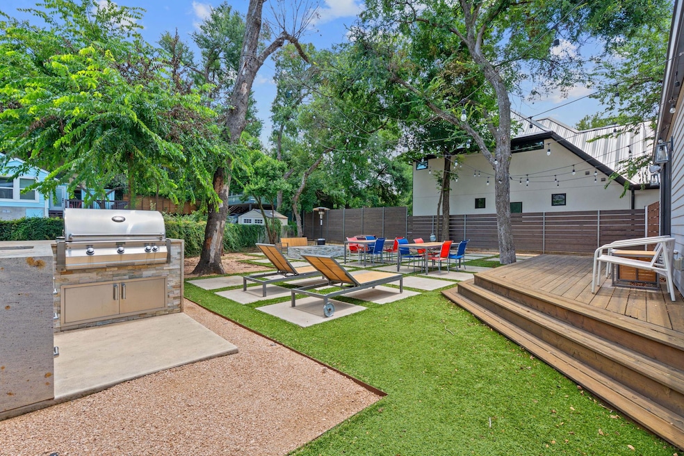 Fenced backyard with a wooden deck, a patio area,