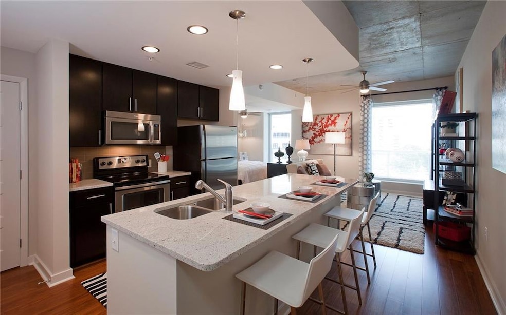 Kitchen with decorative light fixtures, dark hardw