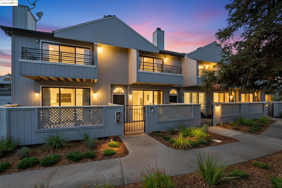 Contemporary house featuring a chimney, a gate, a fenced front yard, and a balcony